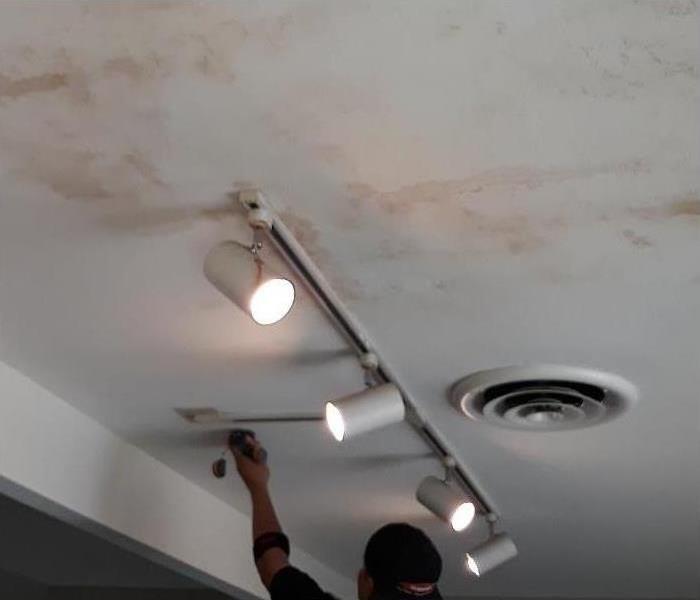 a specialist is checking a water loss in a ceiling